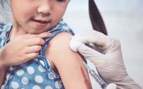 Doctor injecting vaccination in arm of asian little child girl,healthy and medical concept