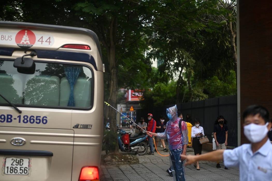A health worker sprays disinfectant on a school bus in Hanoi on 4 May, as schools re-opened after a three-month closure.