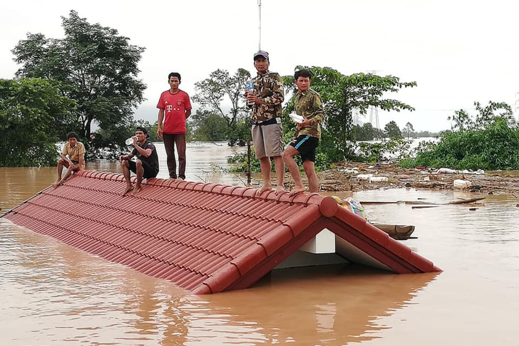 Residents on rooftops surrounded by floodwaters in Attapeu province in southern Laos after a dam collapsed on July 23.
