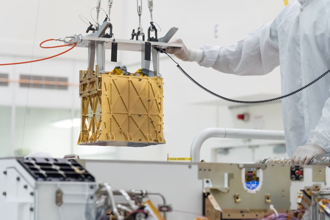 This handout photo obtained April 21, 2021 and released by NASA/JPL shows technicians in the clean room carefully lowering the Mars Oxygen In-Situ Resource Utilization Experiment (MOXIE) instrument into the belly of the Perseverance rover in the cleanroom at NASA's Jet Propulsion Laboratory, in Pasadena, California in March 2019. - NASA's Perseverance rover keeps making history.
The six-wheeled robot has converted some carbon dioxide from the Martian atmosphere into oxygen, the first time this has happened on another planet, the space agency said Wednesday. 
"This is a critical first step at converting carbon dioxide to oxygen on Mars," said Jim Reuter, associate administrator for NASA's space technology mission directorate. (Photo by Ryan LANNOM / various sources / AFP) / RESTRICTED TO EDITORIAL USE - MANDATORY CREDIT "AFP PHOTO / NASA/JPL / Ryan LANNOM " - NO MARKETING - NO...