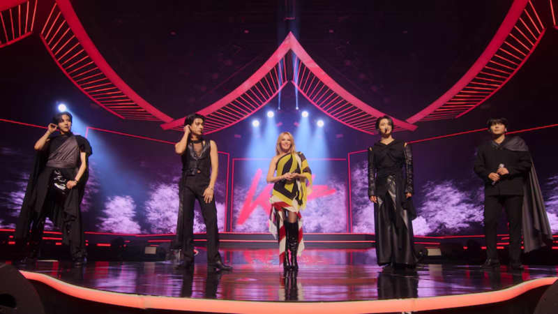 Five performers on a neon-lit stage.