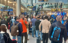 23 September 2025, Denmark, Kopenhagen: Travelers wait at a service counter at Copenhagen Airport. The sighting of several large drones at the airports in Copenhagen and Oslo caused air traffic to be blocked for hours and also caused problems for travelers from Germany.