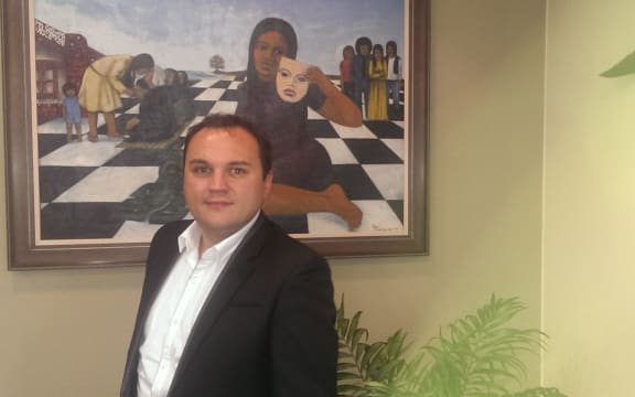Mayor of Porirua, Nick Leggett, in front of a painting by Robyn Kahukiwa.