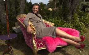 Emma Lange sits outdoors on a pink armchair