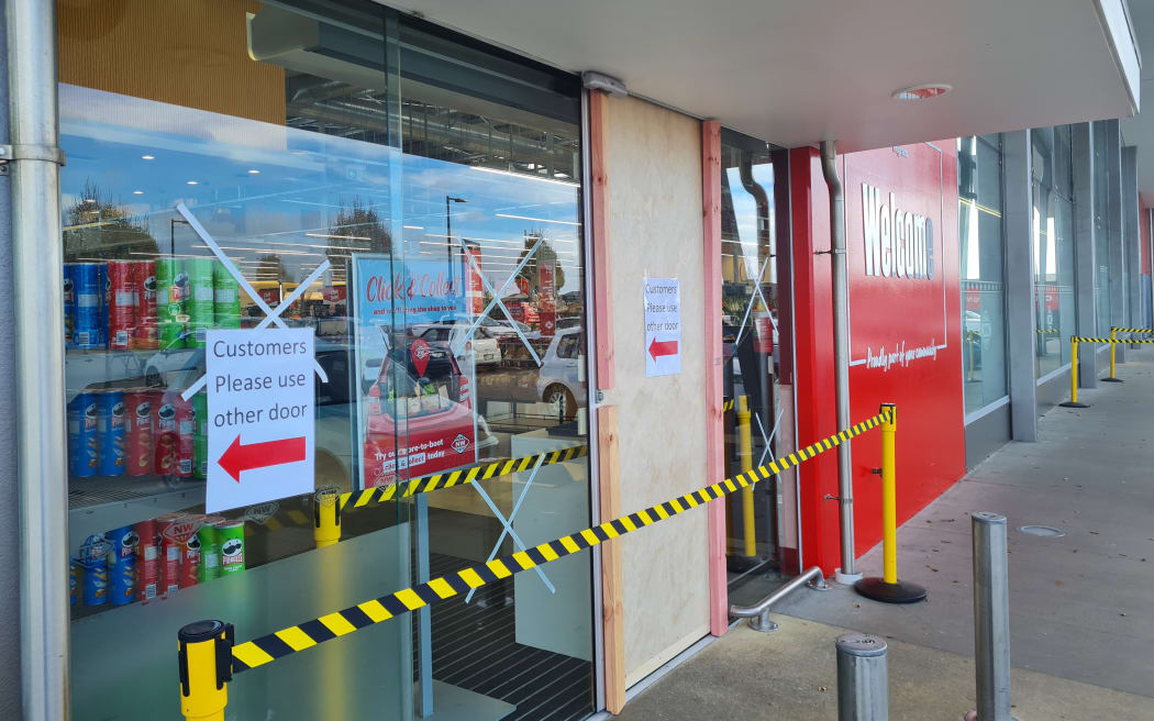 The entry to New World in Wigram, bordered up after its doors were smashed with an axe.