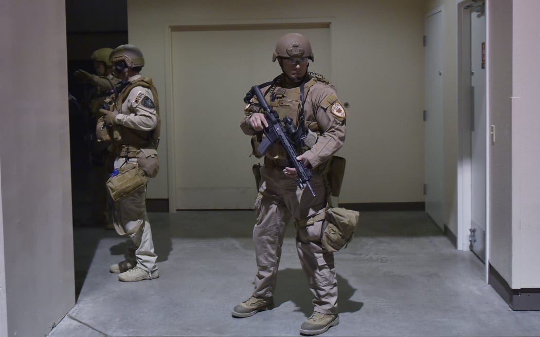 Police outside a bathroom where a protestor was being held after Donald Trump was escorted off stage during the rally.