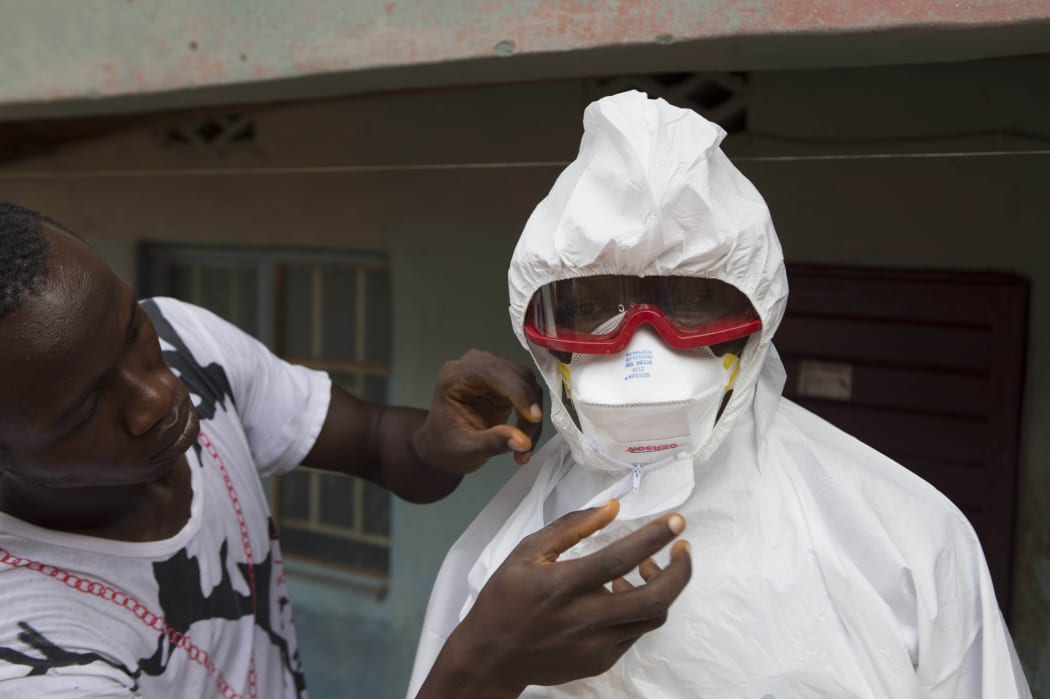 A member of a burial team in Sierra Leone in wearing protective clothing.