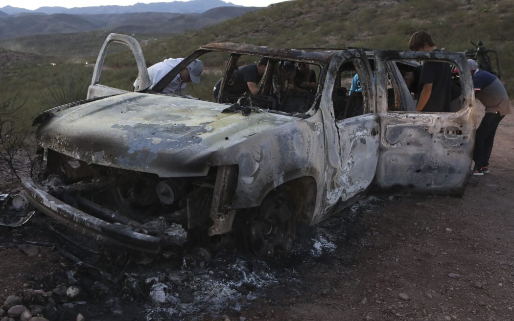 Members of the Lebaron family watch the burned car where part of the nine murdered members of the family were killed and burned during an gunmen ambush on Bavispe, Sonora mountains, Mexico, on November 5, 2019.