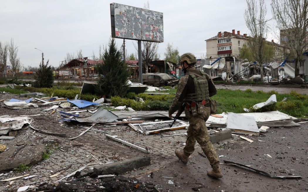 A Ukrainian serviceman walks down a street in the frontline city of Bakhmut, Donetsk region on April 23, 2023, amid the Russian invasion of Ukraine. (Photo by Anatolii Stepanov / AFP)
