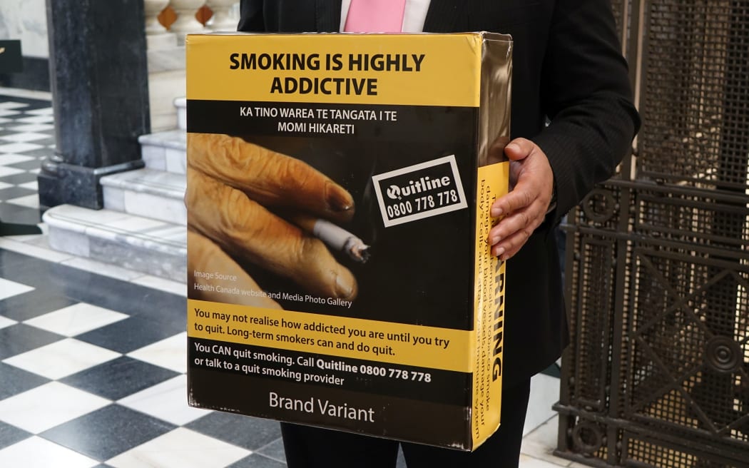 Associate Health Minister Sam Lotu-Iiga with an example of the plain packaging.