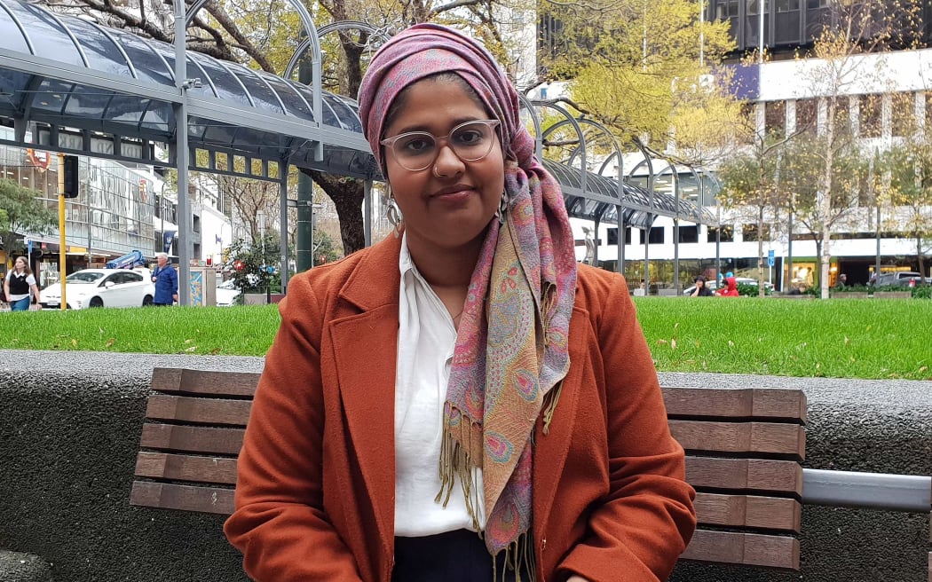 Young woman in headscarf sits in Wellington park