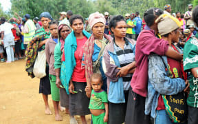 A group of women wait at Lil Care Centre in Nipa district to receive aid.
