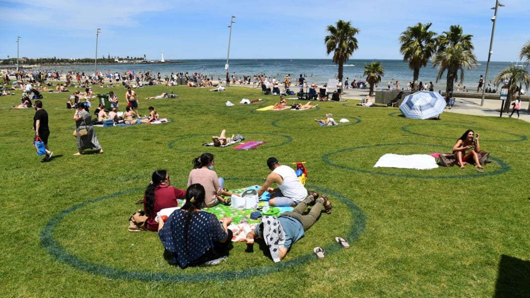 People enjoy the warm weather on Melbourne's St Kilda Beach on November 3, 2020, as Australia's Victoria state records its fourth straight day of zero transmissions of the COVID-19 coronavirus