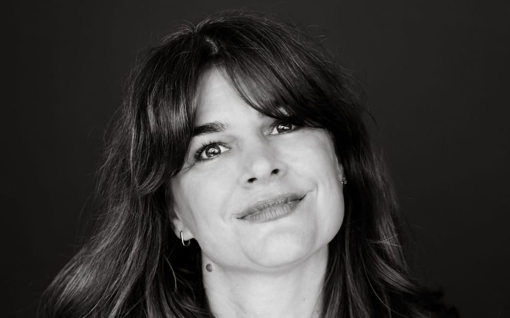 This is a black and white head shot of Jane Ward. She has shoulder length hair and is smiling at the camera.