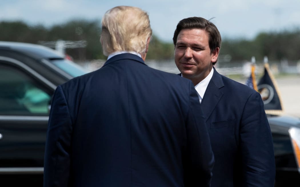 US President Donald Trump is greeted by Florida Governor Ron DeSantis at Southwest Florida International Airport October 16, 2020, in Fort Myers, Florida. (Photo by Brendan Smialowski / AFP)