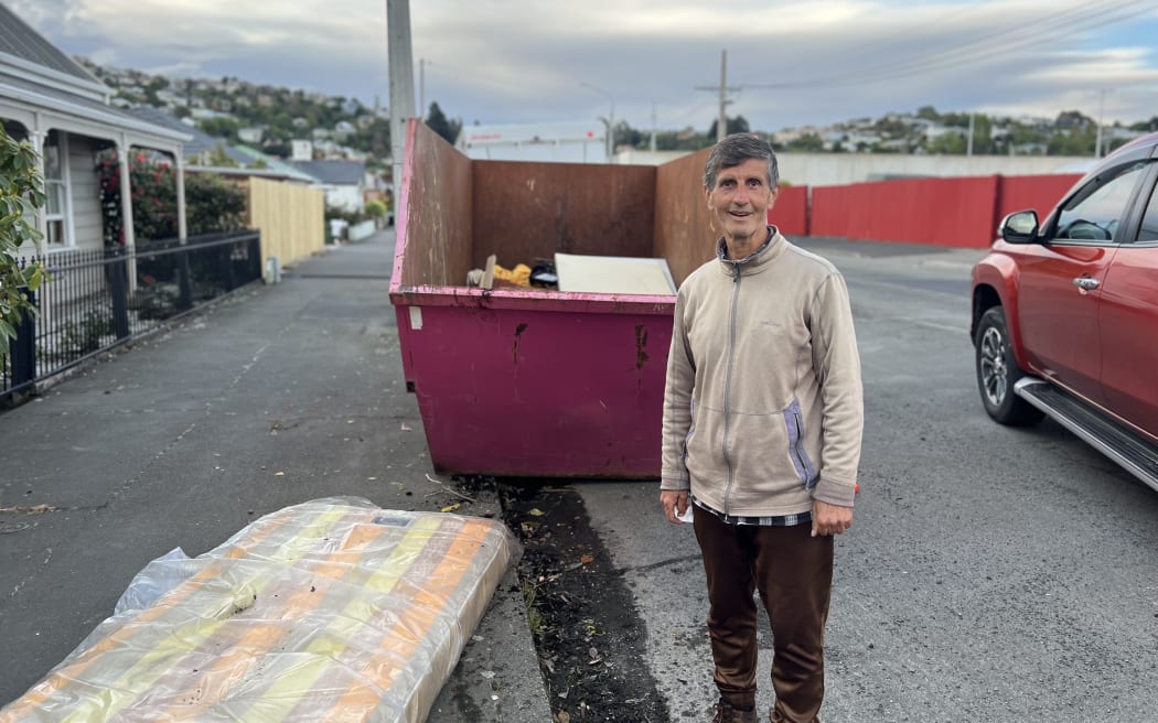 Mo Nicow with his sodden belongings in the skip on 7 October, 2024, after flooding in Dunedin.