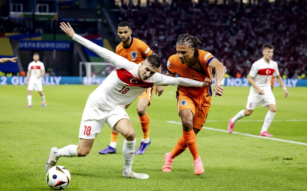 Mert Muldur of Turkey and Nathan Ake of Holland (l-r) during the UEFA EURO 2024 quarter-final match between the Netherlands and Turkey at the Olympiastadion on July 6, 2024 in Berlin, Germany.