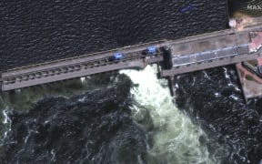 A satellite image shows a roadway and section of Nova Khakovka dam in south Ukraine. Ukrainian President Volodymyr Zelensky will urgently convene his Security Council on June 6, 2023 after an explosion at the Kakhovka hydroelectric dam in the south of the country.