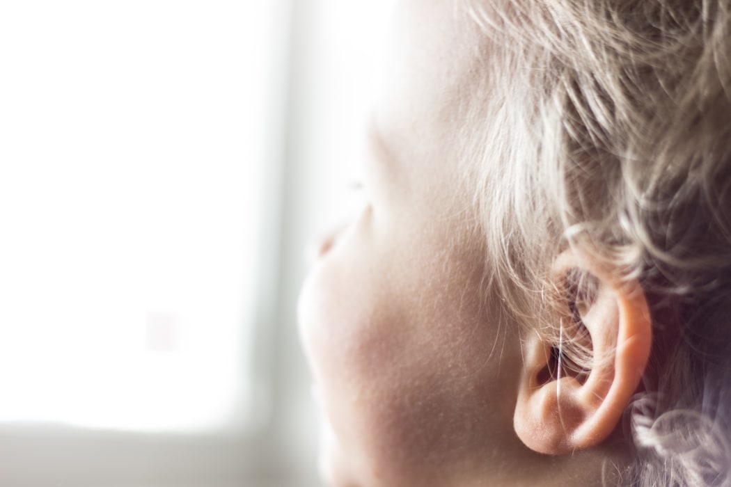 A young child looks out a window