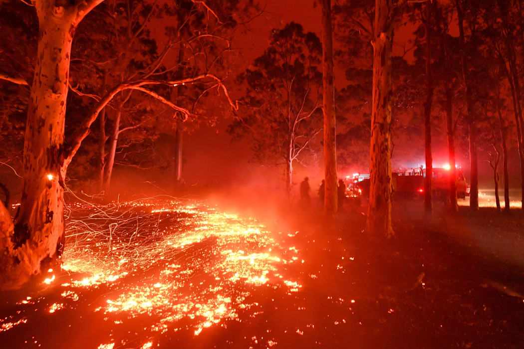 Burning embers cover the ground as firefighters battle against bushfires around the town of Nowra in the Australian state of New South Wales on December 31, 2019.