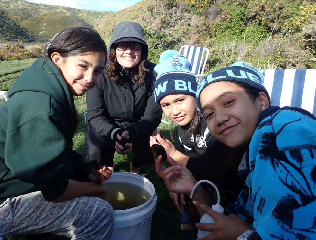 "Kids make the best ecologists," says Amber McEwan. Helping Amber clean the mussels before their move is Ryah-Jane, Perzia-Rose and Harmony Wright.