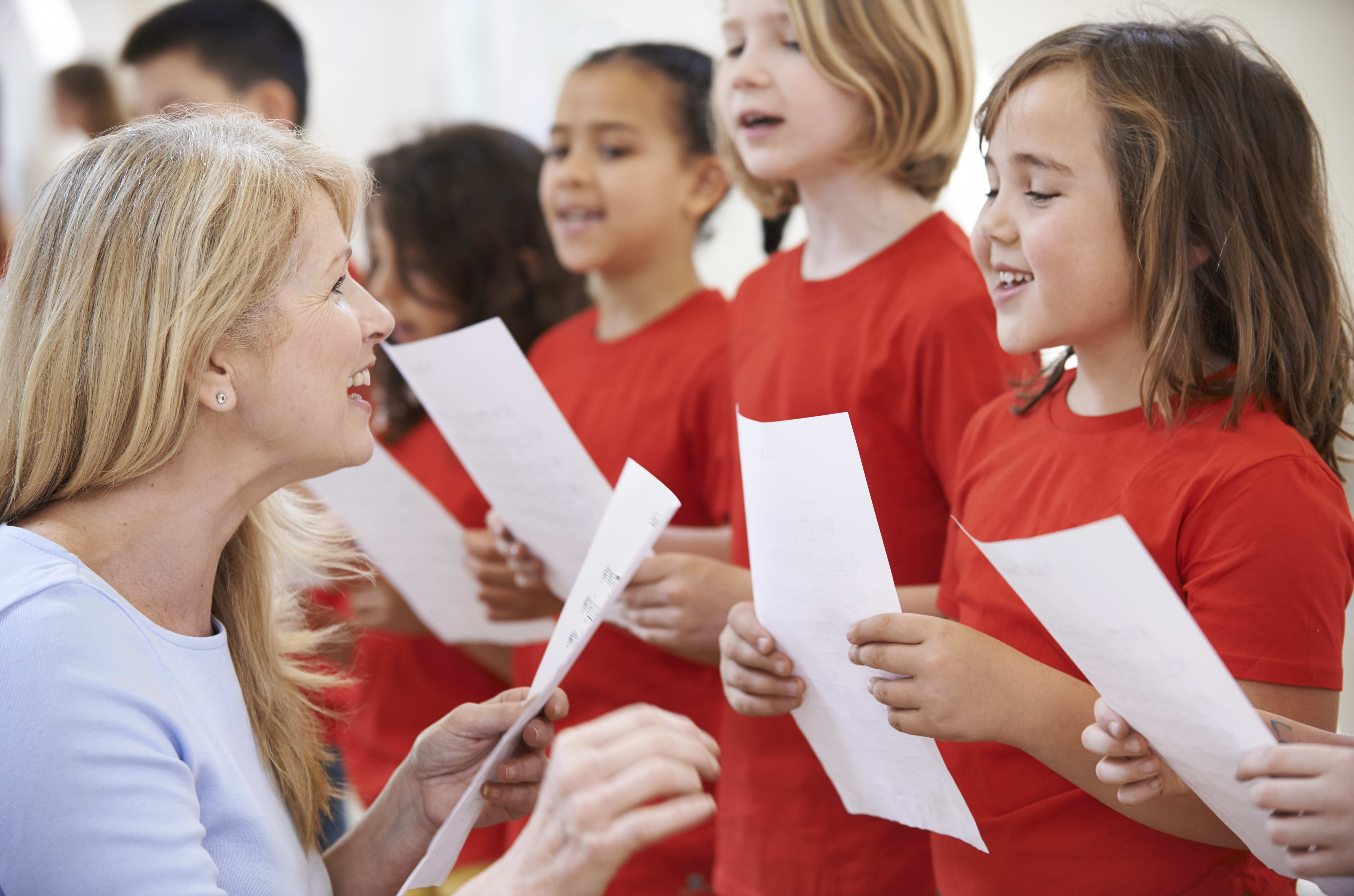 A music teacher helps a group of primary school children singing in a choir (file photo)