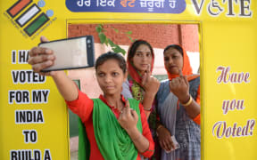 Indian voters pose for a picture with their ink-marked fingers after casting votes at a polling centre on the outskirts of Amritsar.