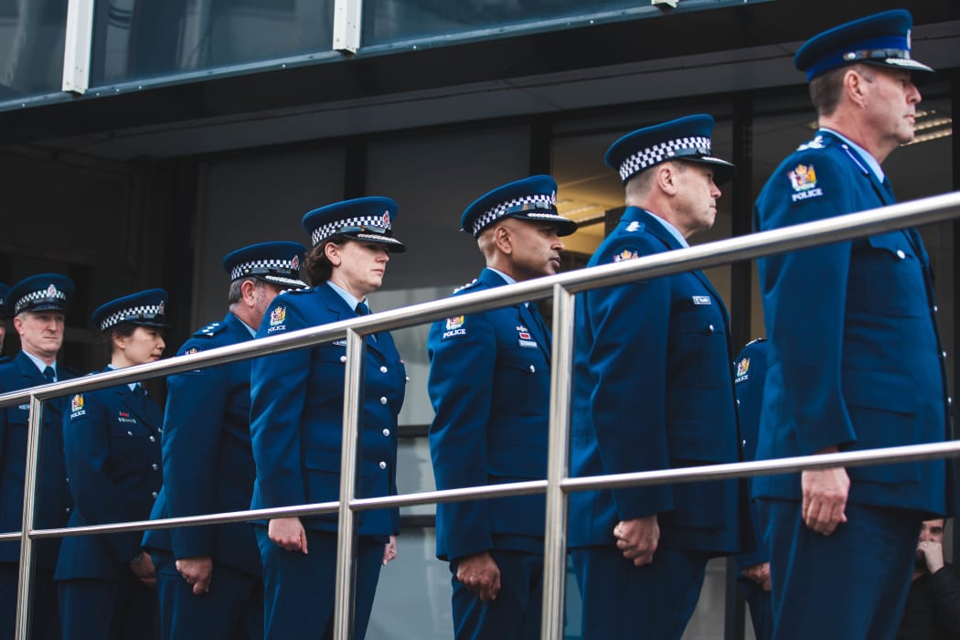 Police officers observe a minute of silence to remember Constable Matthew Hunt at the Memorial Wall in Wellington.
