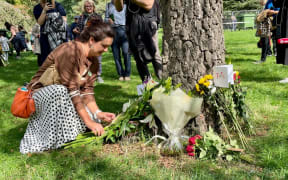 A member of the New Zealand Society in London lays down flowers in memory of the Queen.
