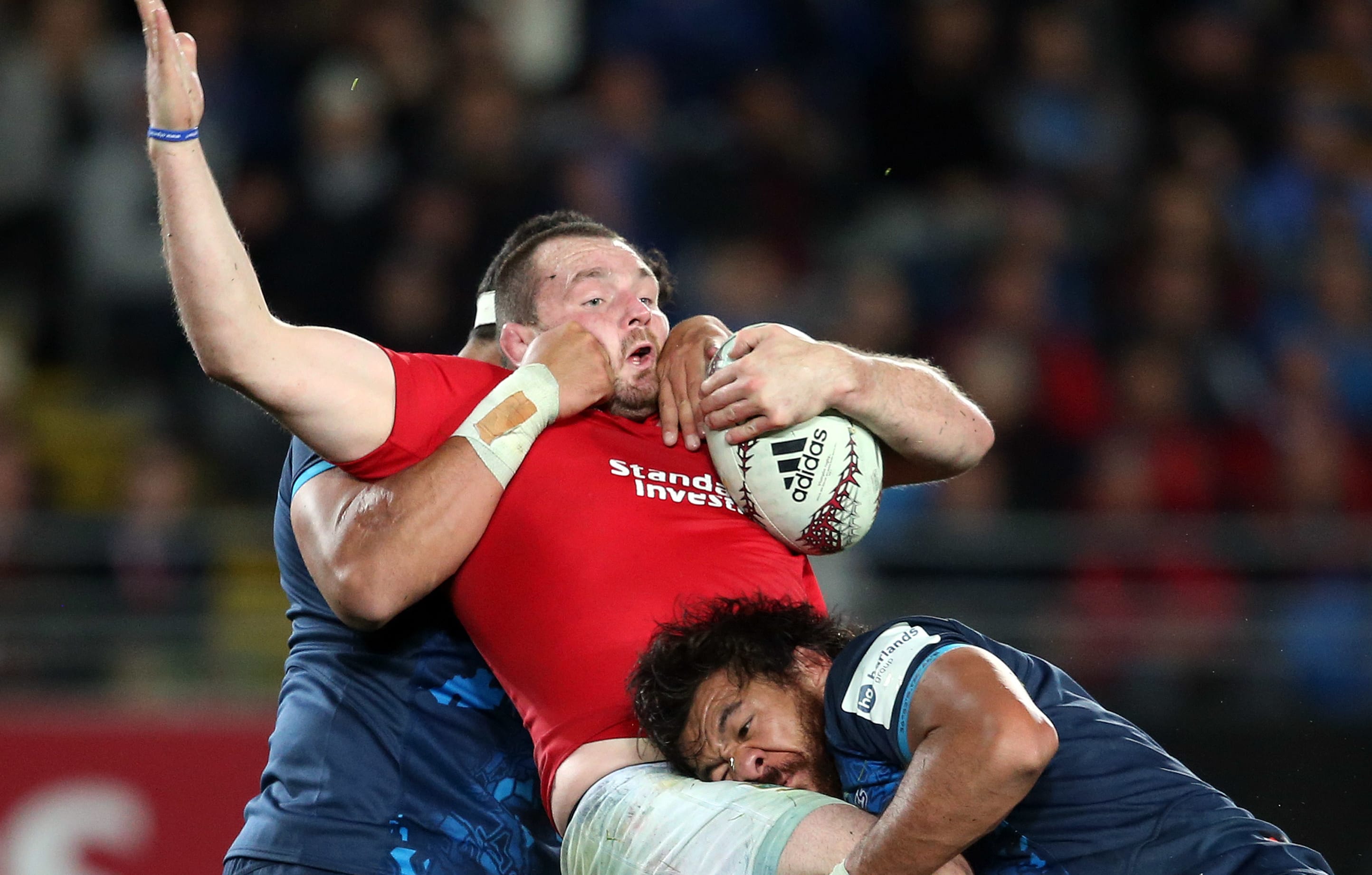 British and Irish Lions captain Ken Owens (C) is tackled by Blues' Alex Hodgman (L) and Steven Luatua (R) during the rugby match between The British and Irish Lions and Auckland Blues at Eden Park.