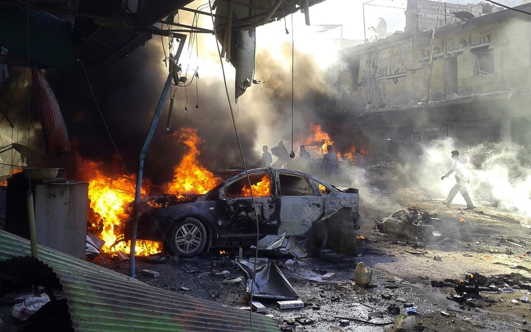 Smoke rises as the car burning after a car bomb blast in October 2013, in Darkush, Idlib, Syria. At least 20 people killed when the car exploded in a bazaar.