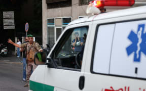 A Lebanese army soldier gestures to an ambulance rushing wounded people to a hospital in Beirut on September 17, 2024, after explosions hit locations in several Hezbollah strongholds around Lebanon.