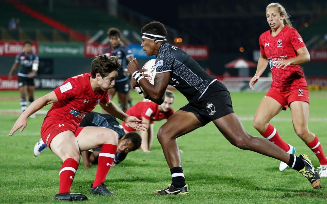 Fiji's Litia Naiqato runs at Canada captain Ghislaine Landry at the Dubai 7s.