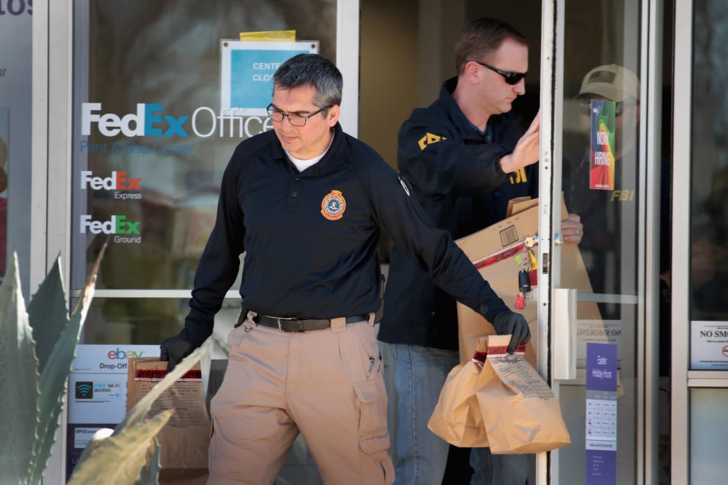 FBI agents collect evidence at a FedEx Office facility following an explosion at a nearby sorting center in Sunset Valley, Texas.