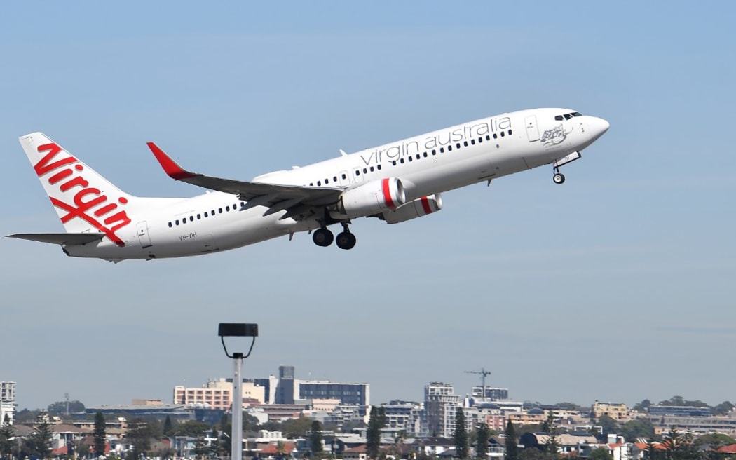 A Virgin Australia plane takes off at Sydney Airport in Sydney on March 19, 2020. -