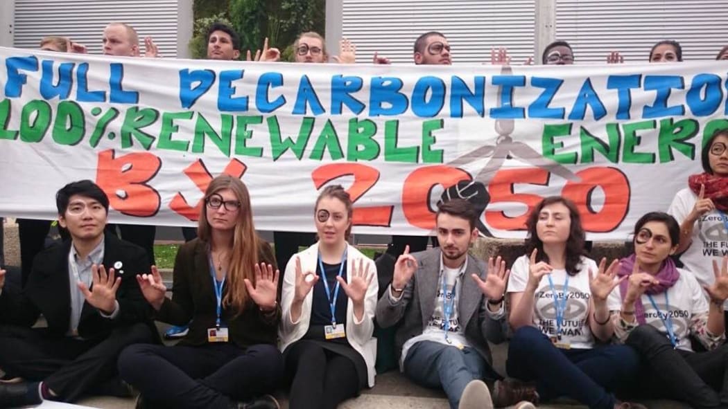 The black zero circle is a youth symbol from COP21 to promote a long-term goal of zero emissions by 2050.