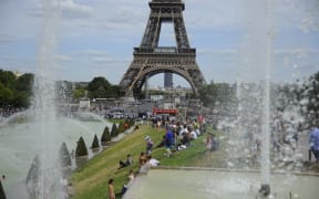 People in front the Eiffel Tower in Paris as temperatures degrees reach 41 Celsius.