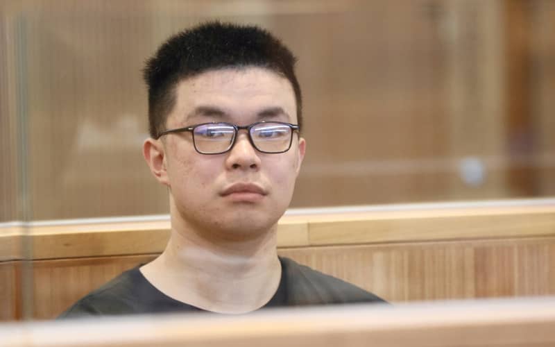 Tiedan Huo in the dock at Manukau District Court at the start of his trial. Huo is accused of a number of offences including unlawful possession of a firearm, explosives and making threats to Waiuku College & Rutherford College in Auckland. 28 July 2026.