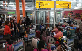 Travellers wait stranded at Heathrow Airport Terminal 5 after British Airways flights where cancelled at Heathrow Airport.