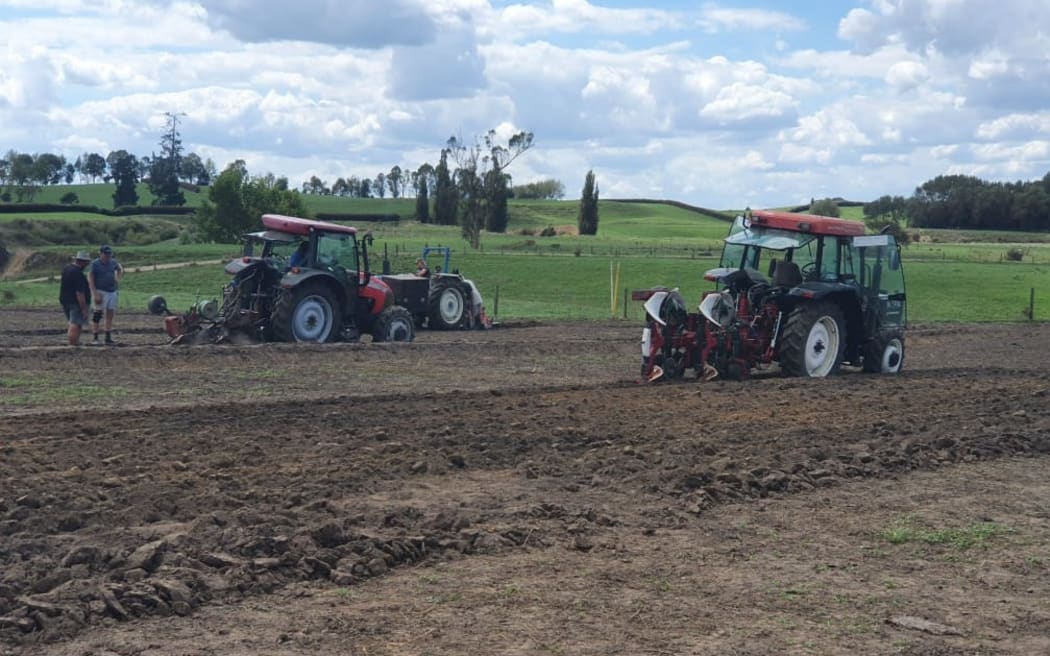 Two tractors ploughing.