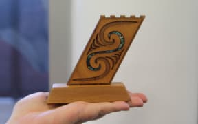 One of the inmates at Arohata Prison holds an award she received from the drug treatment unit.