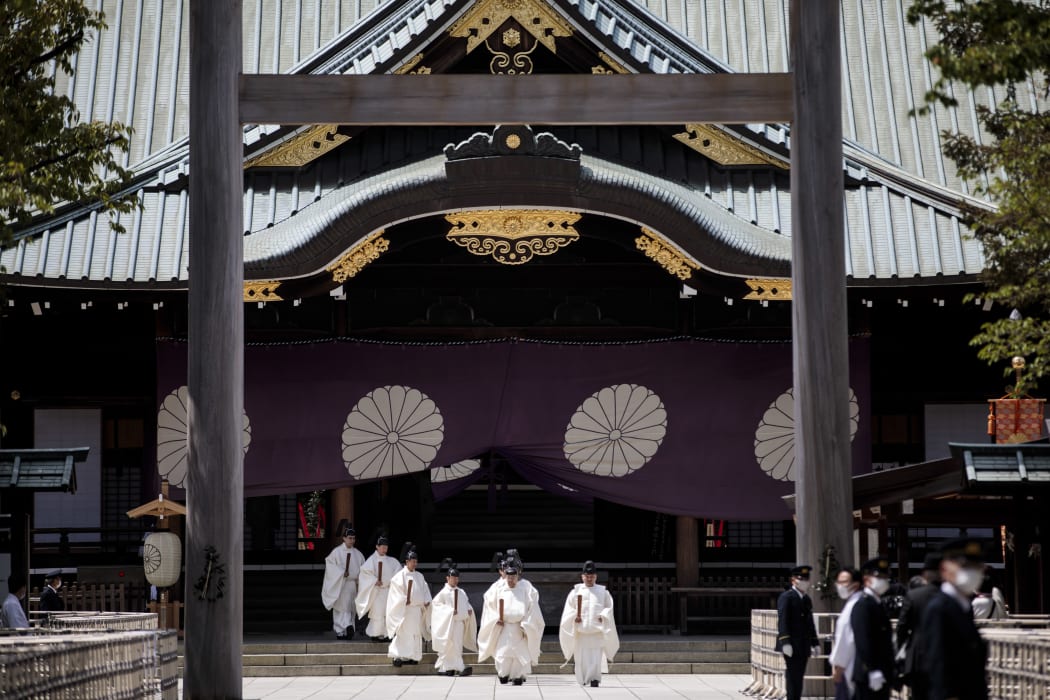 Priests walk at the outer shrine during a Shinto ritual of the annual spring festival at the Yasukuni shrine in Tokyo.