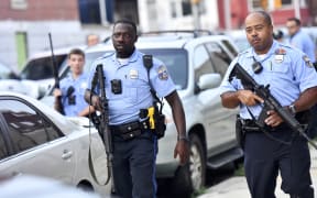 Police officers congregate outside a residence while responding to a shooting on August 14, 2019 in Philadelphia, Pennsylvania. At least six police officers were reportedly wounded in an hours-long standoff.