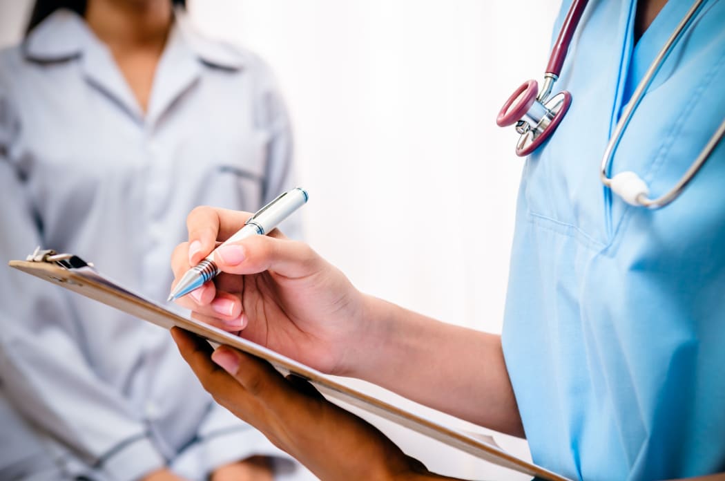 Doctor with clipboard takes patient's notes