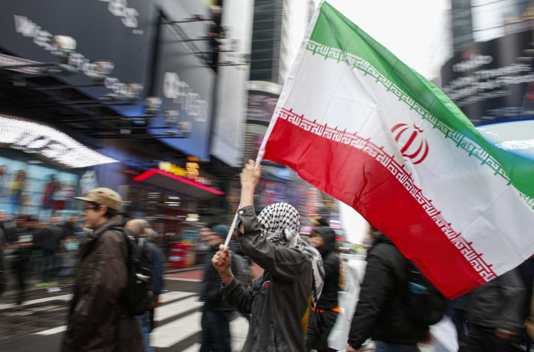 A man holds a Iranian flag during an anti-war protest, at Times Square in New York on January 4, 2020.