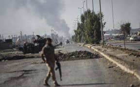Iraqi forces wait in the town of Gogjali, on Mosul's eastern edge, as they head to the main hub city during a military operation to retake it from Islamic State.