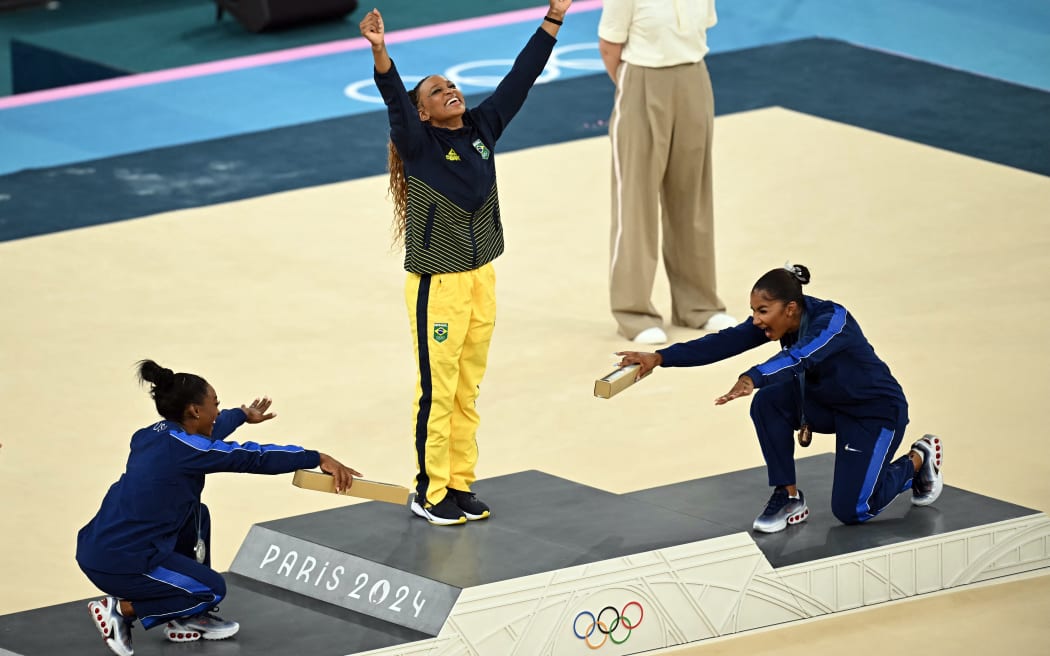 (LtoR) US' Simone Biles (silver), Brazil's Rebeca Andrade (gold) and US' Jordan Chiles (bronze) pose during the podium ceremony for the artistic gymnastics women's floor exercise event of the Paris 2024 Olympic Games at the Bercy Arena in Paris, on August 5, 2024. (Photo by Paul ELLIS / AFP)