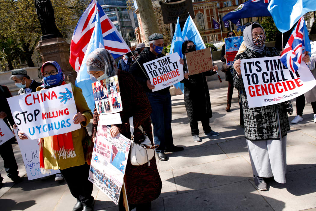 Members of the Uyghur community and human rights activists demonstrate outside the Houses of Parliament in London on 22 April 2021.