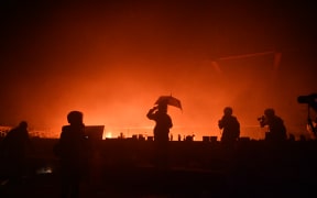 A large fire burned near an entrance to a besieged Hong Kong campus on November 18 morning after protesters threw Molotov cocktails to fend off a police advance on the university, according to AFP reporters at the scene.