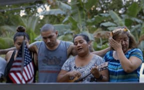 Maryann Nena sings by the grave of her son, SGT Sapuro B. Nena, who was killed in action in Afghanistan in 2012.  Mario Robles, to her left, was Sapuro's best friend in the US Army, and he and his family flew to the FSM in 2015 to pay their last respects.